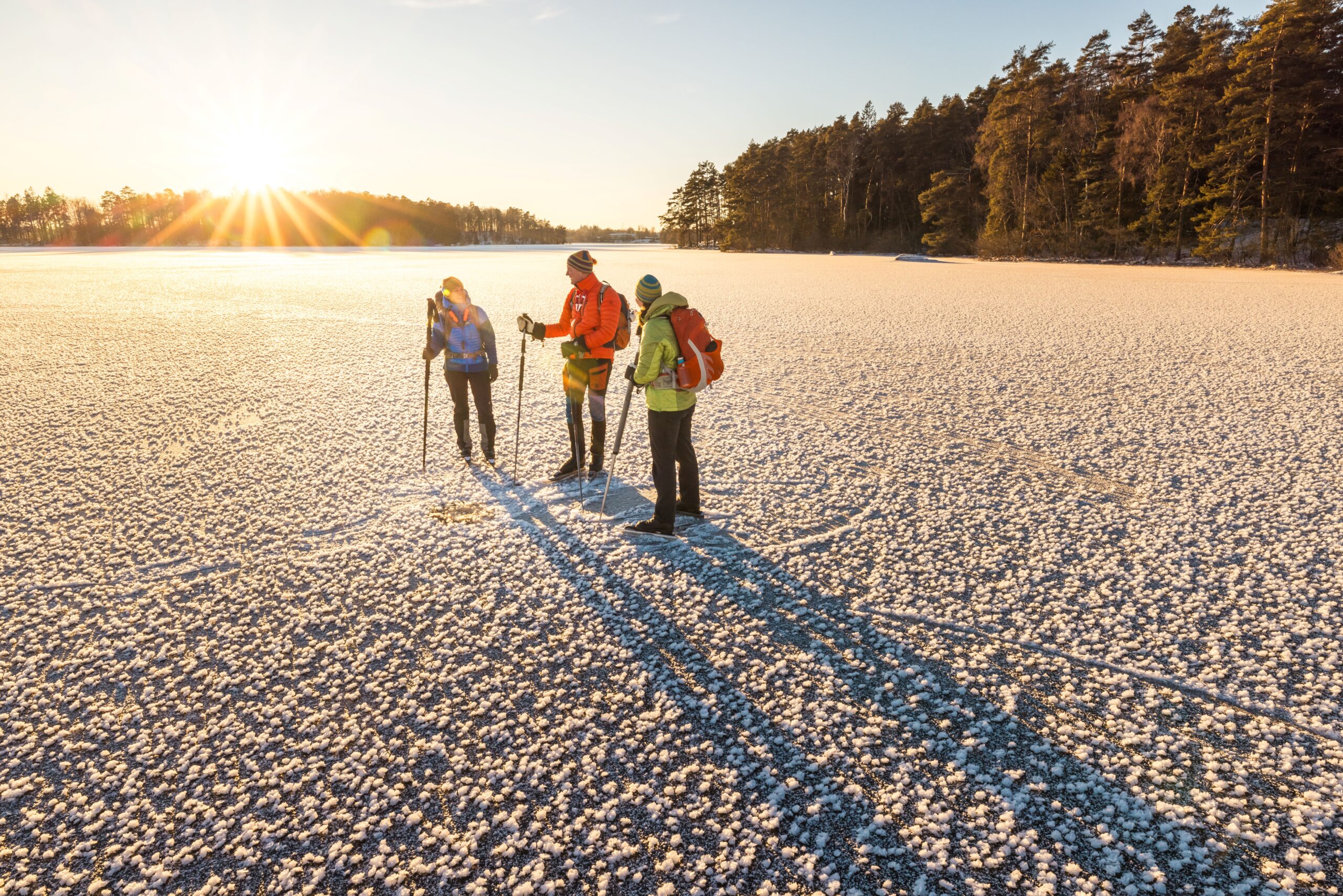 Grupp med vänner vandrar genom snö i vinterlandskap på Hovdala Naturområde.